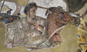 Mosaico romano antiguo que muestra a Alejandro Magno montado a caballo, con armadura decorada, en una escena de batalla, acompañado por soldados.