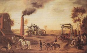 Escena de la Revolución Industrial con maquinaria de vapor, trabajadores, caballos y chimeneas humeantes en un entorno rural, representando el inicio de la industrialización.