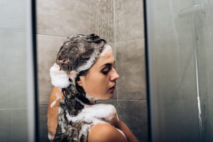 mujer lavándose el pelo con champú