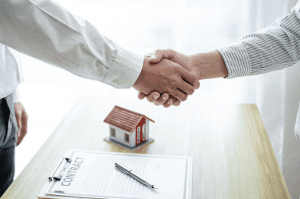 manos estrechadas después de firmar contrato de casa