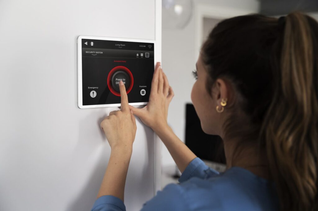 Mujer utilizando un panel táctil en la pared para desactivar el sistema de seguridad inteligente del hogar.