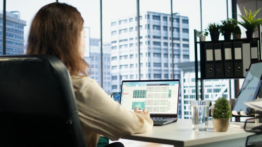 Profesional trabajando con software ERP en ordenador en oficina moderna gestionando datos empresariales