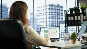 Profesional trabajando con software ERP en ordenador en oficina moderna gestionando datos empresariales