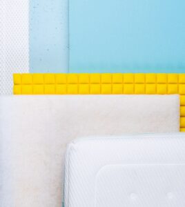 Capas internas de un colchón mostradas en sección, con espuma, tejido acolchado y materiales de confort para descanso y soporte ergonómico.