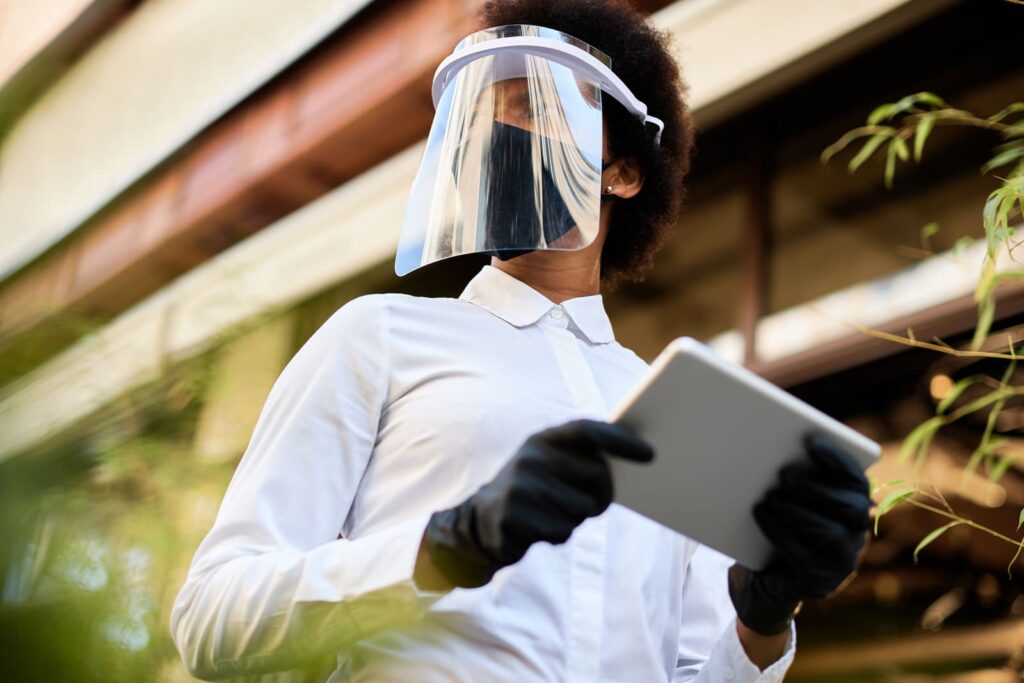 Técnico de control de plagas revisando una zona con tablet y equipo de protección